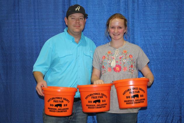 Channing Goodson, right, of Tecumseh 4-H, and Pottawatomie County Free Fair Board Secretary Trent Boles hold her belt buckles for Grand Champion Market Swine, Reserve Grand Champion Market Swine and Gold Belt Buckle High Point Award. Countywide &amp; Sun/Natasha Dunagan