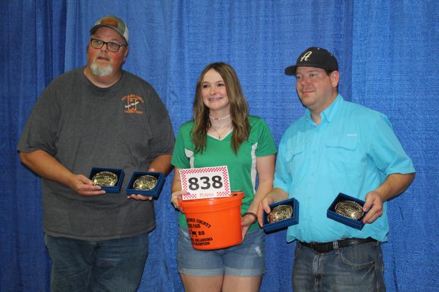 Megyn Alls, of Tecumseh 4-H, poses with Pottawatomie County Free Fair Board Member Tim Underwood, left, and Board Secretary Trent Boles, along with the four belt buckles and bucket won at the Fair. Alls won Grand Champion Overall Male Chicken, Grand Champion Overall Female Chicken, Grand Champion Gelding and Senior Showmanship for the 4-H &amp; FFA Horse Show, Open Senior Dairy Doe in Meat Goats, and Best of Show Outstanding Junior Photograph. Countywide &amp; Sun/Natasha Dunagan
