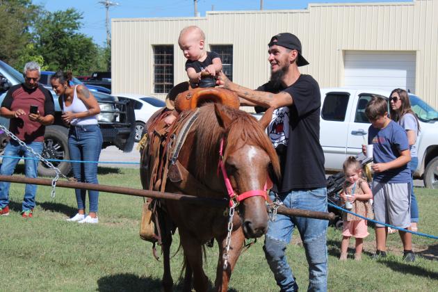 Michael Cisneros, of Shawnee, holds onto his son Andre Cisneros, 9 months, as he rides a pony during Frontier Days on Sept. 17. The pony rides, bounce house, and petting zoo were all in the Kids Zone on the grounds of Broadway Chapel, in Tecumseh. Countywide &amp; Sun/Natasha Dunagan