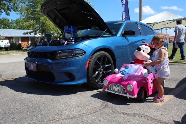 Ember Pritchett, 3, of Luther, cleans her Minnie Mouse car, next to her father's, David Pritchett's 2022 Dodge Charger during the Frontier Days Car Show on Sept. 17. The car show was brought back this year and had 44 entries. Countywide &amp; Sun/Natasha Dunagan