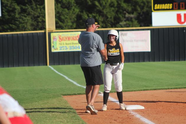 Tecumseh’s Taylor Gage shakes hands with Coach Chad Trahan at third base after hitting a triple during the home game against McLoud, Sept. 19. Countywide &amp; Sun/Natasha Dunagan