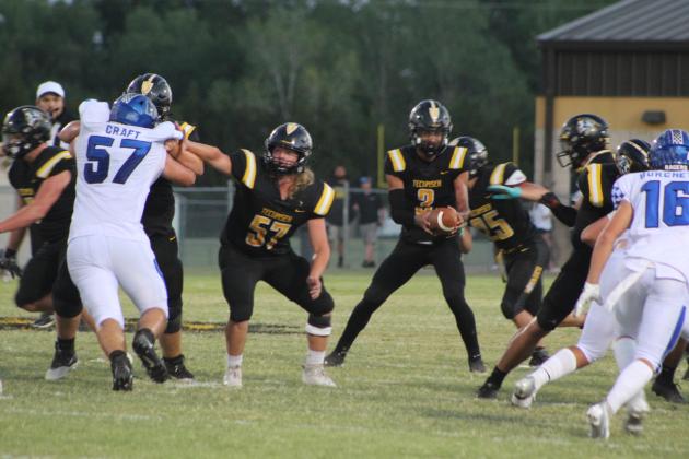 Tecumseh senior Brody Moody (#57) blocks as junior Marquan Krush (#3) hands off the ball during the home game against Newcastle on Sept. 23. After two victories, the Savages fell 7-35. Countywide &amp; Sun/Natasha Dunagan