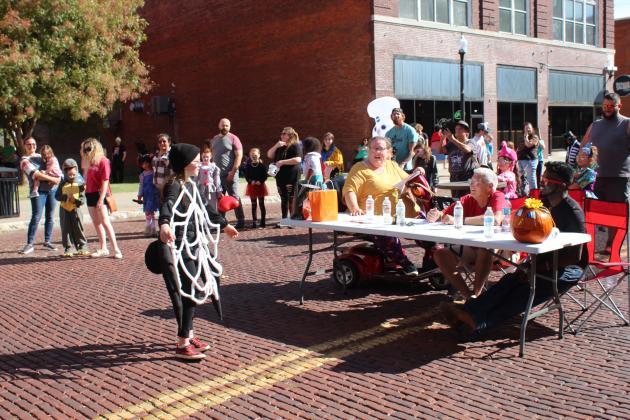 Playing a black widow spider, Abigail Skelly, 10, of OKC shows her web to the judges during the 8-12-year costume contest at Monsters on Main in downtown Shawnee on Oct. 22. Skelly said she made the costume herself, and she won first place. Countywide &amp; Sun/Natasha Dunagan