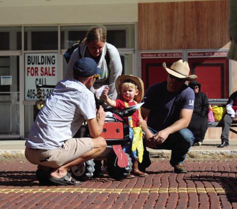 “Rodeo Clown” Layton Cannon, of Shawnee, fist bumps M.C. Waylon Sewell, as his parents Brittany and Bo Cannon look on during the 0-3 year costume contest at Monsters on Main in downtown Shawnee, Oct. 22. Bo Cannon is actually a firefighter clown for fire prevention presentations. Layton won third place. Countywide &amp; Sun/Natasha Dunagan