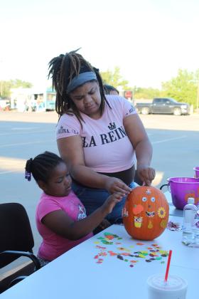 Ebony Barkus and Tiyana Carson, 6, both of Shawnee, decorate a pumpkin during the Frenzy on Federal on Oct. 1. Countywide &amp; Sun/Natasha Dunagan