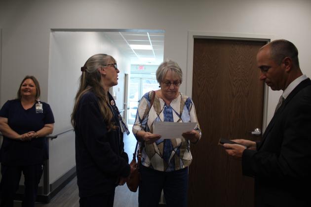 RN Tamara Cummings hands Army Veteran Sharon Johnson a paper explaining how to transfer to the Shawnee VA Clinic, as OKC VA Director Wade Vlosich assists in transferring her using his phone. Johnson recently moved from Florida to Shawnee. She served at the Pentagon in communications for three years. The new Shawnee site held its Grand Opening on Oct. 21. Countywide &amp; Sun/Natasha Dunagan