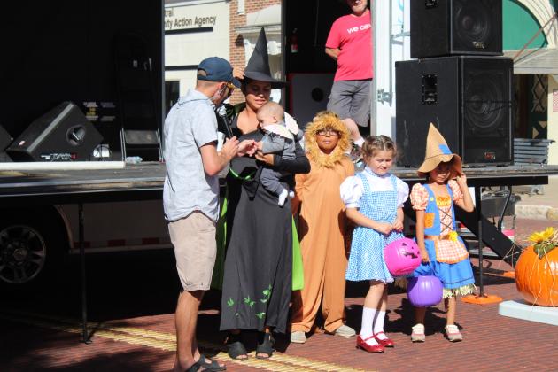 M.C. Waylon Sewell talks to Serena Neely during the family costume contest at Monsters on Main in downtown Shawnee, Oct. 22. Also shown, from left, are Merritt Neely, 6 months; Kellan Neely, 9; Peyton Neely, 7; and Prestynn Neely, 6. They won first place. Countywide &amp; Sun/Natasha Dunagan