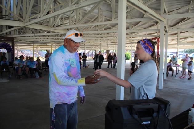 House of Hope Color Fun Run organizer Kayla Woody, right, presents a trophy to the "Oldest Male" participant on Oct. 1 at the CPN Festival Grounds. Countywide &amp; Sun/Natasha Dunagan