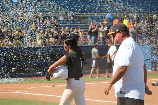 Tecumseh pitcher Serenity Jacoway and Head Coach Perry Wilson walk to the dugout from first base after the seventh inning, as Lone Grove celebrates their Class 4A State Fastpitch Championship win with confetti at the USA Softball Hall of Fame Complex on Oct. 15. The Lady Savages lost in the Finals, 0-3, after winning in extra innings during both the Quarterfinals with Cache, 2-1, and the Semifinals with Miami, 3-0. Countywide &amp; Sun/Natasha Dunagan