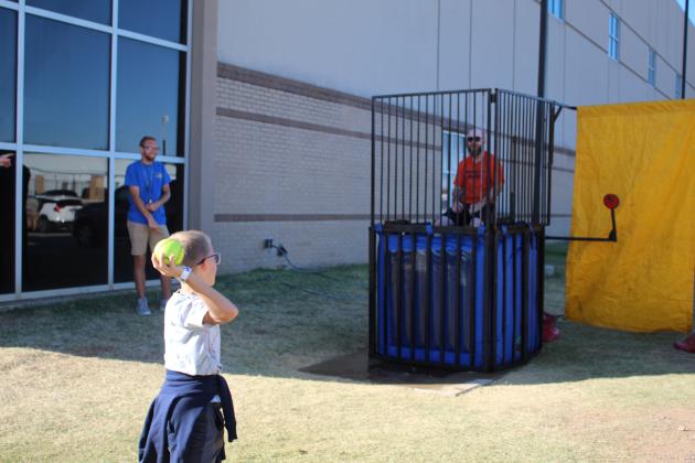 Lucas Lomeli, 10, of Shawnee, throws a ball at the dunk tank, containing Shawnee Middle School wrestling coach Bobby Cox during the Shawnee Wrestling Carnival on Oct. 13 at Shawnee High School. It also included a bake sale, inflatables, dunk tank and carnival games.