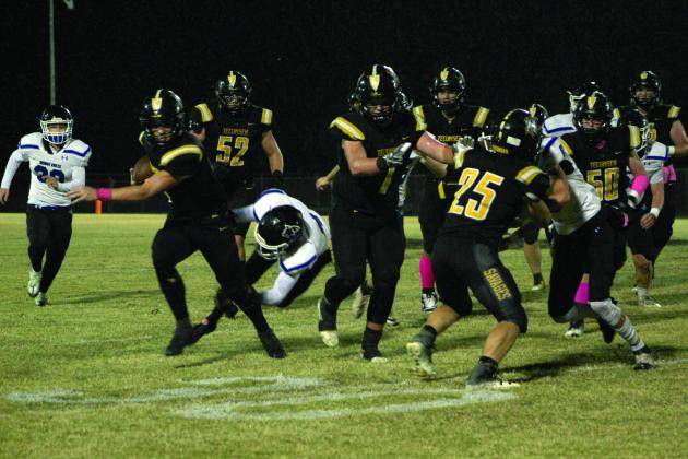 Tecumseh senior Garrett Chaffin carries the ball during the first quarter as a Bridge Creek defender tries to trip him up. Despite rain, the Savages won the Pink Out home game on Oct. 28, 39-14. Countywide &amp; Sun/Natasha Dunagan
