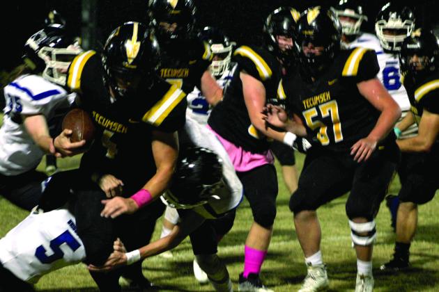 Tecumseh senior Garrett Chaffin (#4) carries the ball during the first quarter as Bridge Creek defenders try to trip him up. Despite rain, the Savages won the Pink Out home game on Oct. 28, 39-14. Countywide &amp; Sun/Natasha Dunagan