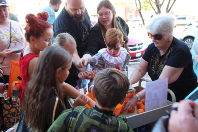 Tecumseh Library Assistant Jerilyn Hart offers temporary tattoos and oranges during Tecumseh Business Trick-or-Treat on Oct. 31. Countywide &amp; Sun/Natasha Dunagan