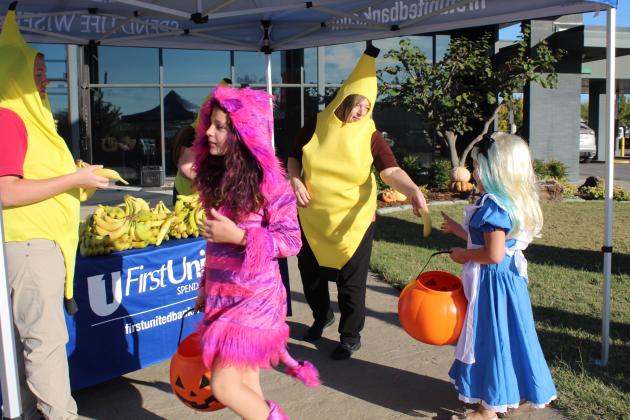 First United Bank employees Elijah Lichty and Lori Villines hand out bananas to Ariel Arms, 10, and Trinity Arms, 7, during the Tecumseh Business Trick-or-Treat, Oct. 31. Bank President Jill Spencer said this is the second year they have dressed as bananas and given out the fruit. Last year, they bought 300 bananas, and this year, they went through nearly 600 bananas. Countywide &amp; Sun/Natasha Dunagan
