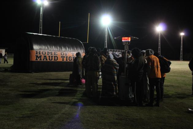 With the temperature around 28 degrees, several people huddled around a heater during halftime of the Class C OSSAA Quarterfinal home game in Maud on Nov. 18. Countywide &amp; Sun/Natasha Dunagan