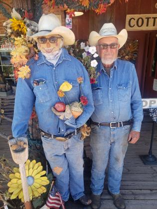 Jim Smith, right, poses with "Honey Dew Jim" at the Farmer's Daughter Market. His wife, Deann, said she used his clothes and other items for the scarecrow, so it is a striking resemblance. They won first place in the City of Tecumseh Commercial Scarecrow Contest. Countywide &amp; Sun/Natasha DunaganThe Make It Yours cowboy scarecrow, at 115 N. Broadway, won third place in the City of Tecumseh Commercial Scarecrow Contest. Photo provided.