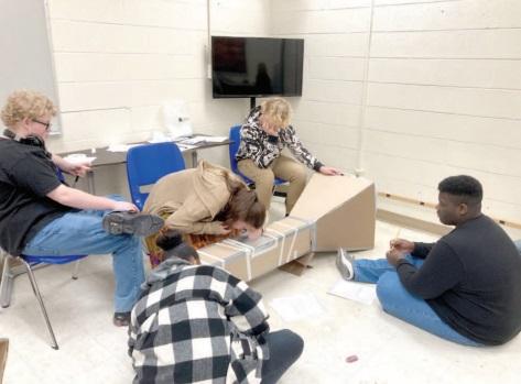 "Launching Into Aviation" students Ozzy Weeks, JaKaila Hurst-Roscoe, Grace Sturgell (looking in window), Sylus Wakolee, and Jake Ceasar test airfoils in a wind tunnel last week at Shawnee High School. Photo provided by Joshua Watson.