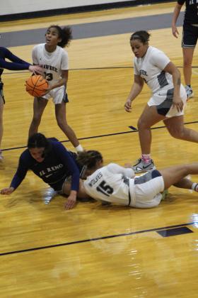 Shawnee's Tarilyn Thierry (#13) eyes the basket as her teammate Tristyn Napier (#15) collides with an El Reno player and Anneca Anderson watches the situation during the home game on Nov. 29. The Lady Wolves lost 28-42. The Wolves also lost that night, 31-45. Countywide &amp; Sun/Natasha Dunagan