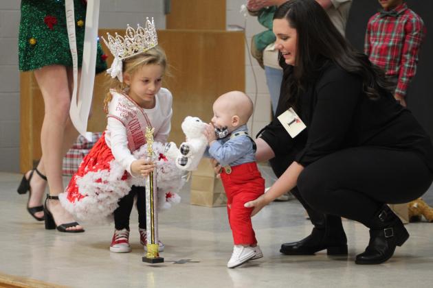 Kyler Searles, National Queen for Our Diamond Miss from Kansas, presents Huxley James, of TX, with the Overall Christmas King Award for the 0-12-month boys division during the Christmas Miss &amp; Mister Pageant on Dec. 3. Countywide &amp; Sun/Natasha Dunagan