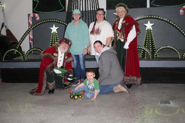 Three generations pose with Santa &amp; Mrs. Claus: Bryson Osborn, 3, of Konawa, front, Aunt Amber Grimsley, kneeling, Great Great Grandma Cherry Bennett, in green, and Great Grandma Michelle Osborn.