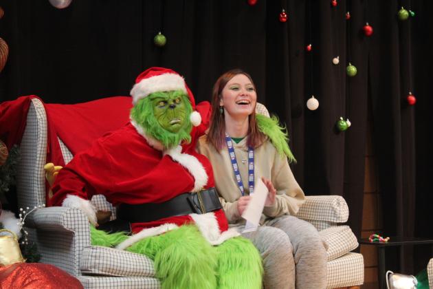 Tecumseh High School Drum Major Chloe Dawson accepts the first-place award for the Savage Pride Marching Band and poses with the Grinch in "Whoville" on Dec. 8. Douglass High School took second, and Cushing took third in the Marching Band Contest. Countywide &amp; Sun/Natasha Dunagan