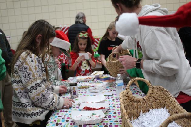 Children make "snow globes" and angel ornaments for nursing home residents at one of the Home Church booths in "Whoville." The church also had a booth to decorate gift bags and one with face painting. Following the Grinchmas Holiday Parade and Marching Band Contest, free photos with the Grinch, free cocoa and games were also available in "Whoville" at the Tecumseh City Hall Auditorium on Dec. 8. Countywide &amp; Sun/Natasha Dunagan