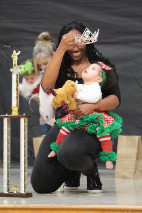 Mia Vernor, of Missouri, watches her crown, as the Overall Christmas Baby in the 10-23-month division of the Christmas Miss &amp; Mister Pageant on Dec. 3. Countywide &amp; Sun/Natasha Dunagan