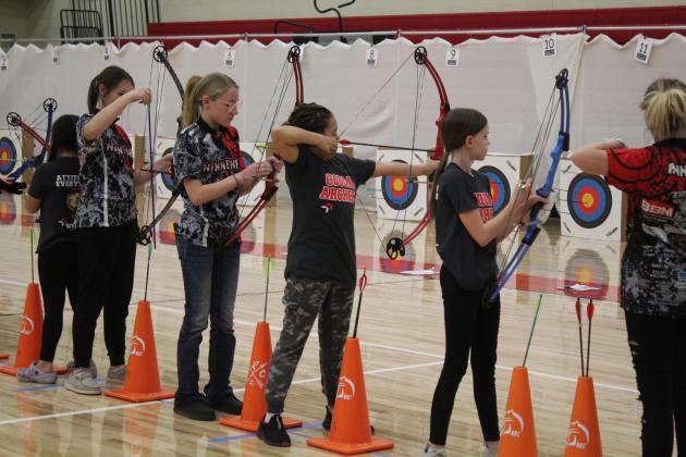 North Rock Creek students Savannah Talton and Jaclyn Robertson (in "Cougar Archery" shirts) compete next to those from Ninnekah during the NASP Tournament at NRC Middle School Jan. 13-14. Countywide &amp; Sun/Natasha Dunagan