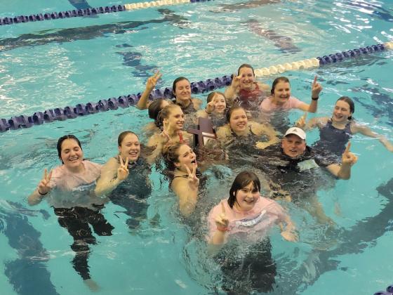 The Shawnee High School Girls Swim Team - along with Head Coach Valarie Colburn and Assistant Coach Bob McNeil - take to the pool to celebrate their Class 5A state victory for the second year in a row. Photo provided.