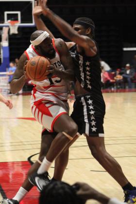 Potawatomi Fire Center Chris Brand tries to get past a Rockwall 7'er guard during the fourth quarter of the first home game, March 17, at FireLake Arena. The Fire won, 152-96. Countywide &amp; Sun/Natasha Dunagan