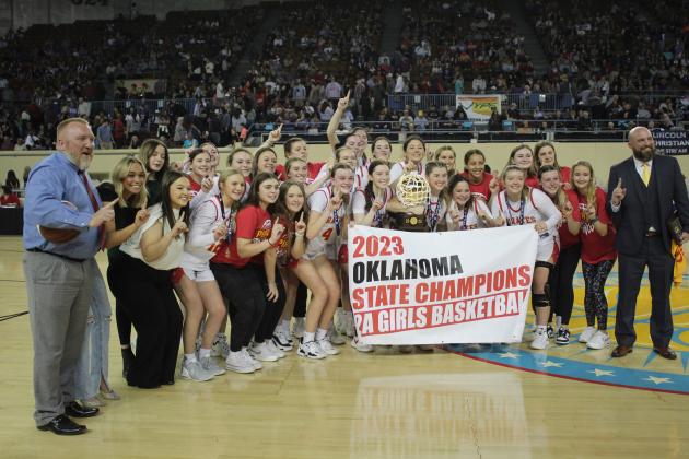 The Dale Lady Pirates and their coaches - Assistant Scott Wilson, far left, and Head Coach Eric Smith, far right - pose with the Class 2A State Championship trophy and banner on March 11 at the State Fairgrounds Arena. On the way to this moment, they beat Hooker, 46-21, in the Quarterfinals; Amber-Pocasset, 52-47, in the Semifinals; and Howe, 48-23, in the Finals. Their season record is 31-2. Before this, the Lady Pirates won seven state basketball championship between 1978 and 2010.