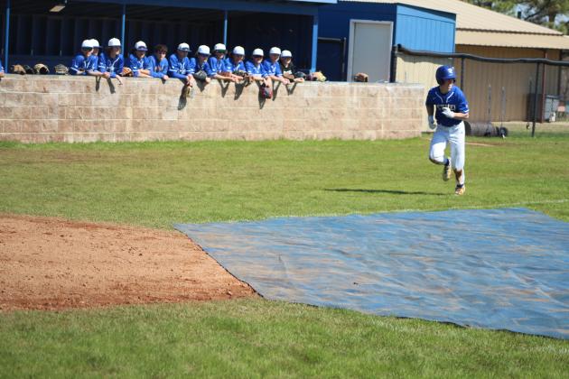 As his team watches from the dugout, Bethel sophomore Bryce Tapley steals home during the Bethel Baseball Bash game against the Bethel Alumni Team on March 4. The baseball season kick-off event also offered a bounce house and food truck. Bethel's first official game was March 6. Countywide &amp; Sun/Natasha Dunagan