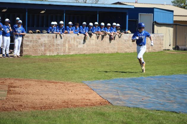 As his team watches from the dugout, Bethel sophomore Bryce Tapley steals home during the Bethel Baseball Bash game against the Bethel Alumni Team on March 4. The baseball season kick-off event also offered a bounce house and food truck. Bethel's first official game was March 6. Countywide &amp; Sun/Natasha Dunagan