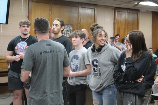 Head Wrestling Coach Andrew McCune introduces the wrestlers who placed in regional or state competition during the Shawnee Board of Education meeting on March 6. Logan Cash, far left, won first in the heavyweight division, only the third in Shawnee history to do so. The others, from left, are Chaysin McClain, Blayne Taber, Za’Karia McClain and Eliana Banks. Countywide &amp; Sun/Natasha Dunagan