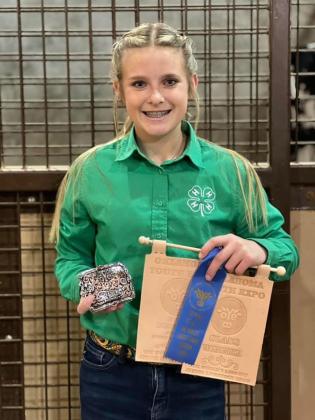Tecumseh's Kreightyn Rodgers poses with her winnings from the Oklahoma Youth Expo, in OKC, this month. Rodgers' sheep won "11th Overall Black-Faced Cross Lamb." Photo provided.