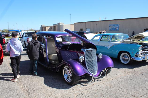 Two boys walk by a 1933 Ford Tudor owned by Wayne Lewis during the 7th Annual Bethel Band Boosters Car Show, held at Bethel High School on April 8. The Tudor won second in the Street Rod class. To the right is a 1955 Ford Crown Victoria owned by Raymond Langley. Countywide &amp; Sun/Natasha Dunagan