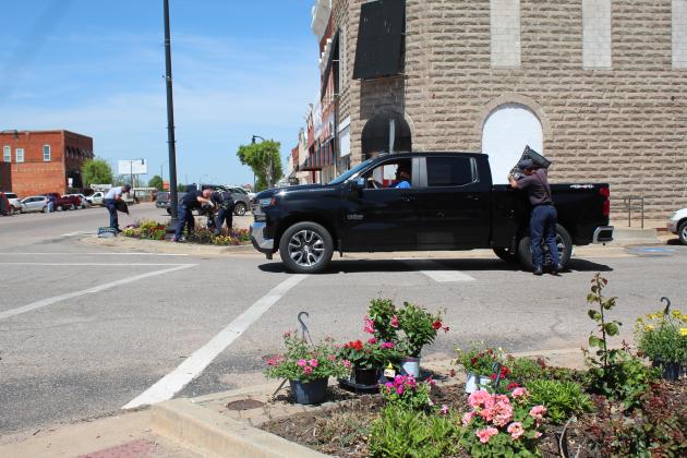 Cathy Condit makes a run for more flowers, as the Tecumseh firefighters finish spreading mulch.