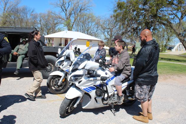 Corey Brown, 11, of Shawnee, and Gideon Youngblood, 10, of Tecumseh, have a seat on two Shawnee Police Department motorcycles, as Cpl. Rich Rider, between them, supervises during the Touch-A-Truck and Beyond event at the CPN Festival Grounds on April 1. Also shown are Cpl. Vivian Lozano, far left, and David Youngblood, far right. Countywide &amp; Sun/Natasha Dunagan