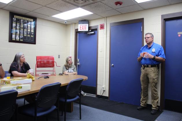 Tecumseh Police Chief J.R. Kidney speaks during the Tecumseh Chamber of Commerce monthly TAG meeting, May 11, as Kimberly Elliott and Becky Webb listen. Countywide &amp; Sun/Natasha Dunagan