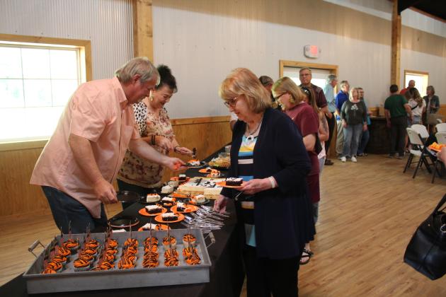 A retirement reception was held for Dr. Bob Evans, DVM, at Crossing Hearts Ranch on May 21, and there was a crowd on hand to wish him well, including the venue owners Randy and Suzanne Gilbert, shown serving cake. Countywide &amp; Sun/Natasha Dunagan