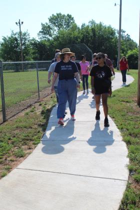 Holly Gordon, of the Gateway to Prevention TSET Healthy Living Program, walks and talks with Adriana Watson, 11, on the new 1/2-mile walking trail at Slick Humphrey Park in Tecumseh on June 8. Gordon also spoke at the TAG meeting held at the park that day. Countywide &amp; Sun/Natasha Dunagan