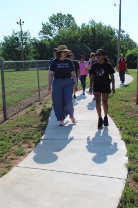 Holly Gordon, of the Gateway to Prevention TSET Healthy Living Program, walks and talks with Adriana Watson, 11, on the new 1/2-mile walking trail at Slick Humphrey Park in Tecumseh on June 8. Gordon also spoke at the TAG meeting held at the park that day. Countywide &amp; Sun/Natasha Dunagan