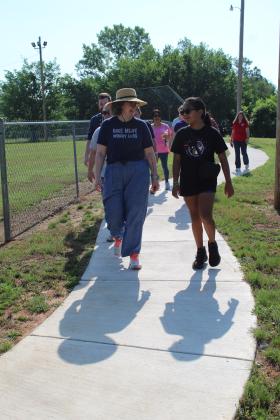 Holly Gordon, of the Gateway to Prevention TSET Healthy Living Program, walks and talks with Adriana Watson, 11, on the new 1/2-mile walking trail at Slick Humphrey Park in Tecumseh on June 8. Gordon also spoke at the TAG meeting held at the park that day. Countywide &amp; Sun/Natasha Dunagan