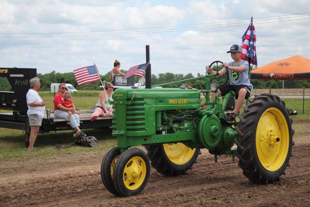Breken Little, 13, of McLoud drives a 1942 John Deere H in  the antique tractor parade of the Farming Heritage Festival at Shawnee Feed on June 17. Hosted by the Shawnee Tractor and Engine Club, the event is in its 24th year and also included several farming demonstrations, tractor pulling, corn shelling and rope making, June 16-17. Countywide &amp; Sun/Natasha Dunagan