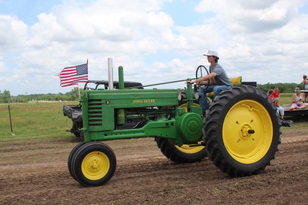 Brody Little, 17, of McLoud, drives a John Deere tractor in the antique tractor parade during the Farming Heritage Festival at Shawnee Feed on June 17. Hosted by the Shawnee Tractor and Engine Club, the event is in its 24th year and also included several farming demonstrations, tractor pulling, corn shelling and rope making, June 16-17. Countywide &amp; Sun/Natasha Dunagan