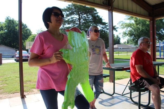 Lisa Watson with the Gateway to Prevention TSET Healthy Living Program holds up a "little green man" as her co-worker Holly Gordon (not shown) tells about it. The bright green signs are used to call attention to pedestrian crossings in high-traffic areas. Also shown are Kim Elliott and Anthony LaGrange. Countywide &amp; Sun/Natasha Dunagan
