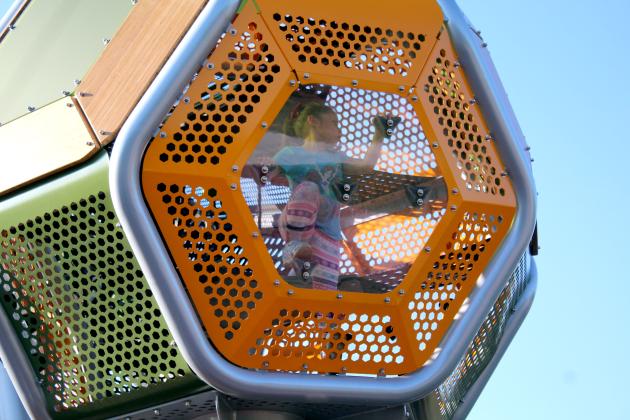Sarah Esquivel, 5, of Shawnee, looks out a window while climbing inside the largest double-slide equipment during the KidSpace Park Grand Opening on June 23. Countywide &amp; Sun/Natasha Dunagan