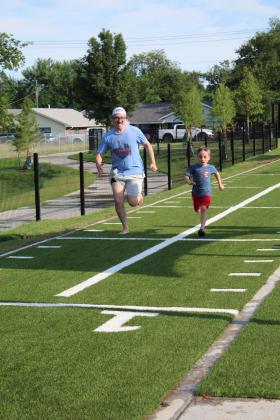 Josh Forrester, left, and Lincoln Forrester, 5, of Tecumseh, race each other in the 40-yard dash during the KidSpace Park Grand Opening, June 23. Countywide &amp; Sun/Natasha Dunagan