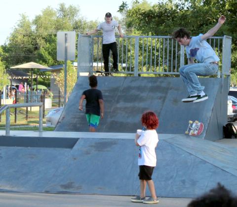Evan McCullough, far right, who recently moved to Tecumseh, performs a skateboard trick during the KidSpace Park Grand Opening on June 23. Waiting his turn is Tim Carr of Shawnee. Several kids got up-close views of the skating demonstration. Countywide &amp; Sun/Natasha Dunagan