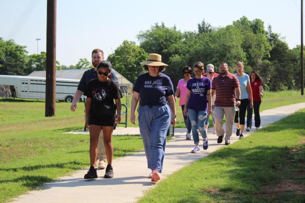 Tecumseh Chamber of Commerce members and representatives from the Gateway to Prevention TSET Healthy Living Program try out the new 1/2-mile walking trail at Slick Humphrey Park during the monthly TAG meeting on June 8. Countywide &amp; Sun/Natasha Dunagan